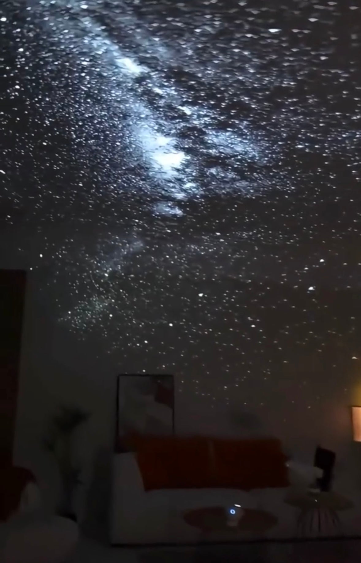 LED galaxy projector on nightstand with ambient glow